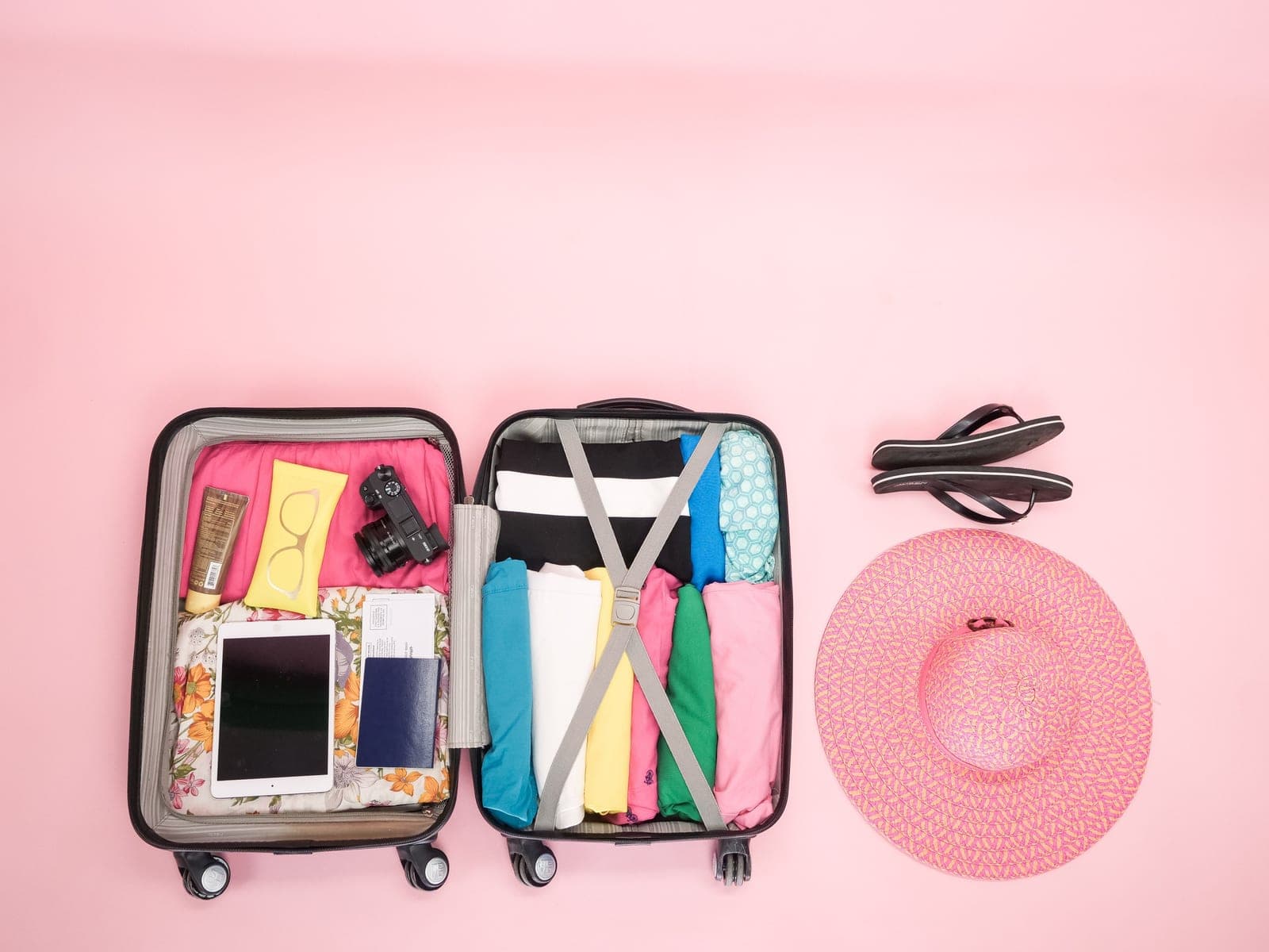 An open suitcase packed with folded clothes and travel essentials