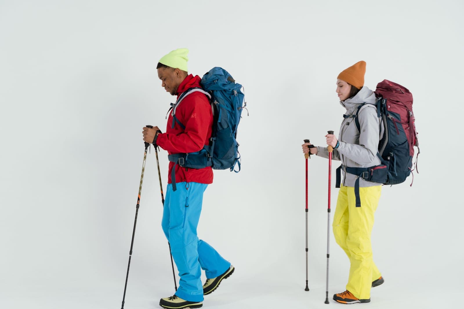 Two hikers in winter gear standing side by side with backpacks
