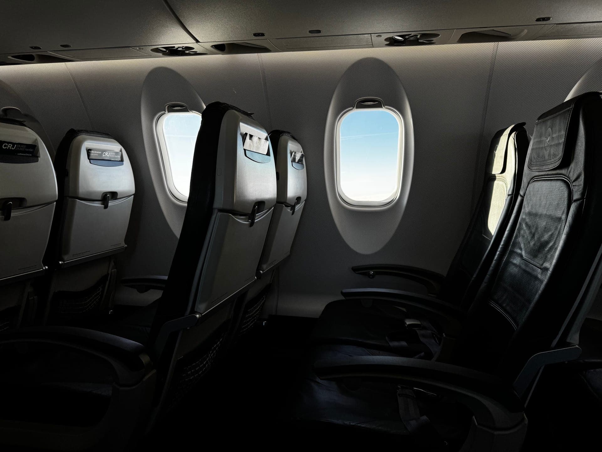 The interior of an airplane cabin looking toward a window seat