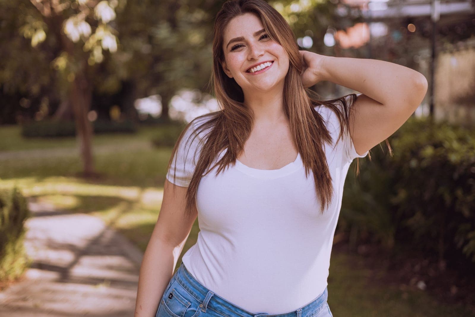 A woman in a white shirt smiling outdoors