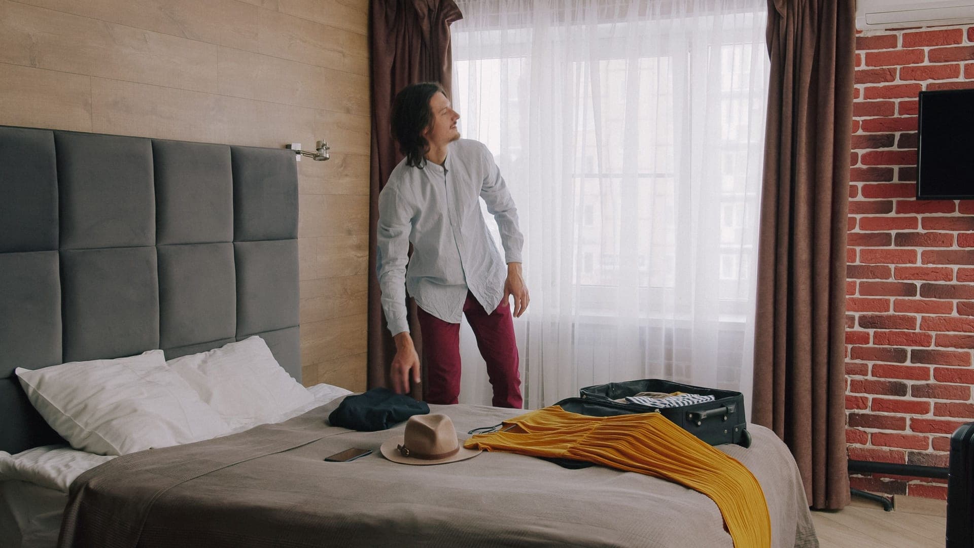 A traveler packing a suitcase in a hotel room